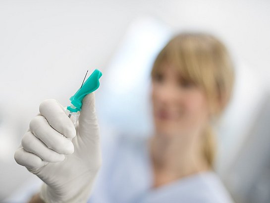 Confident nurse with a hypodermic needle in their hand.